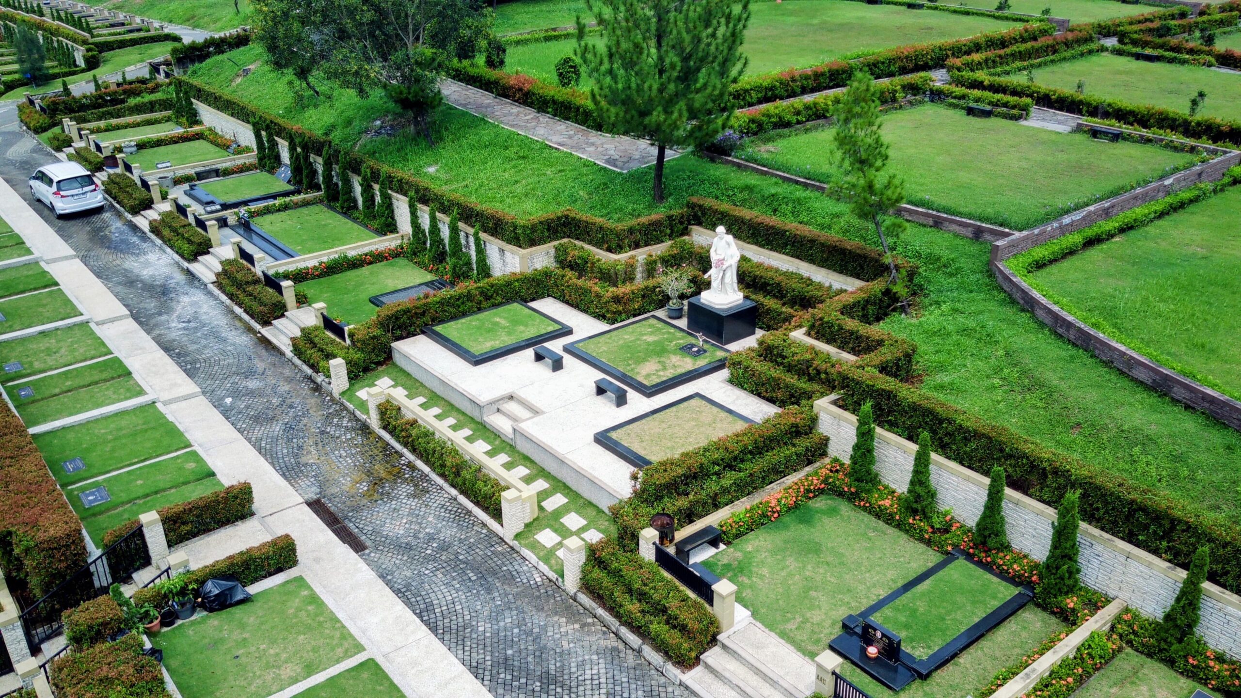 Area pemakaman Universal di San Diego Hills dengan taman hijau yang tertata rapi dan patung marmer putih