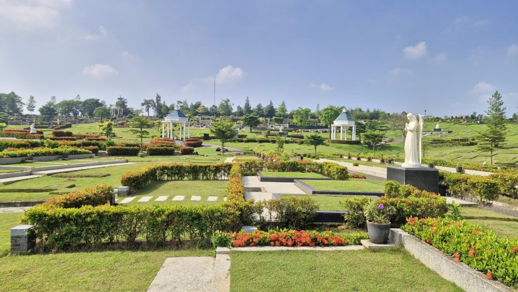 Lahan makam tipe Private di San Diego Hills dengan ornamen patung malaikat putih, taman terawat, serta gazebo ikonik di latar belakang.